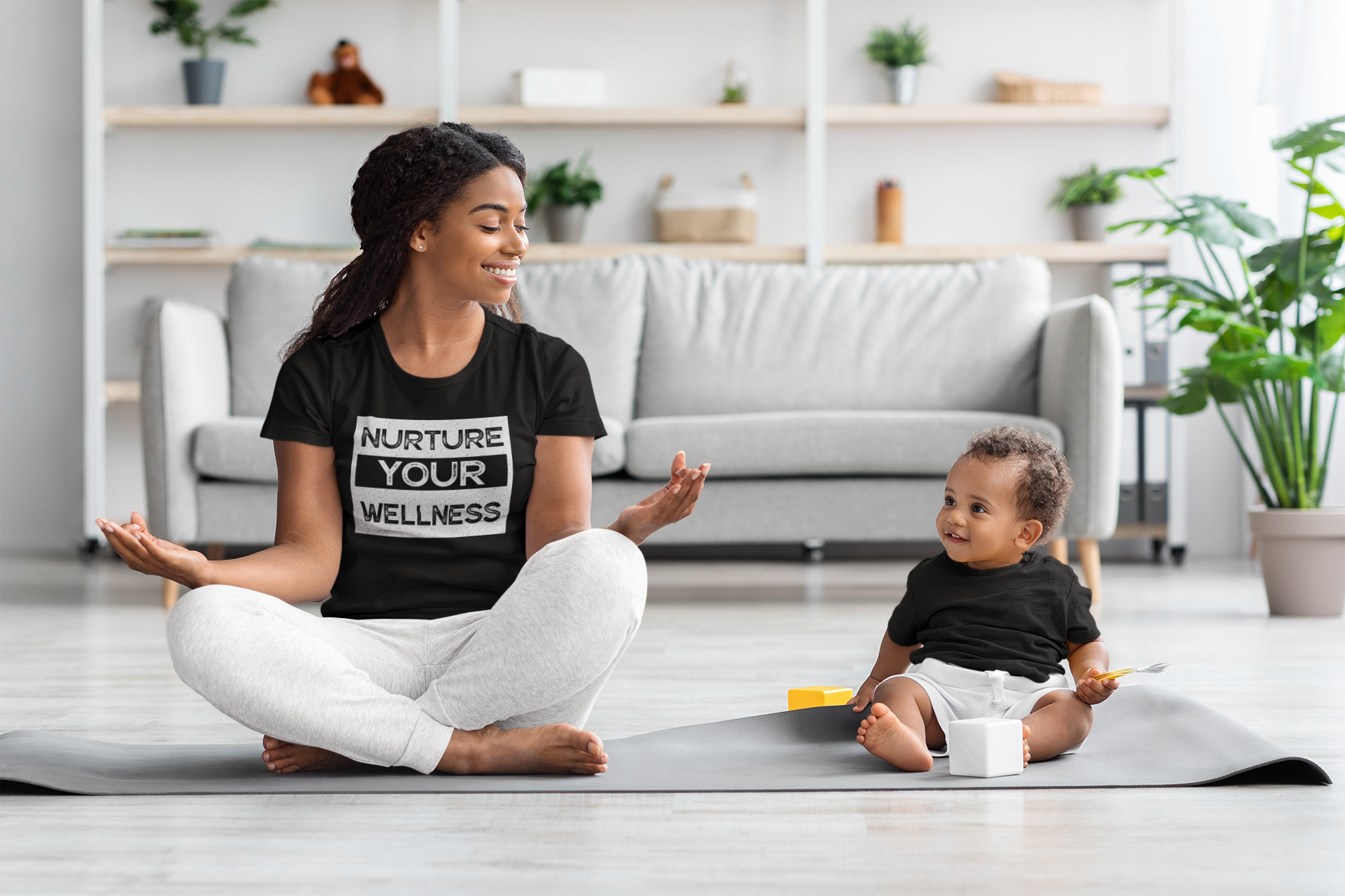 Nurture-Your-Wellnes-Selflove-mockup-of-a-woman-wearing-a-t-shirt-and-meditating-with-her-baby-at-home-m21564-r-el2.png